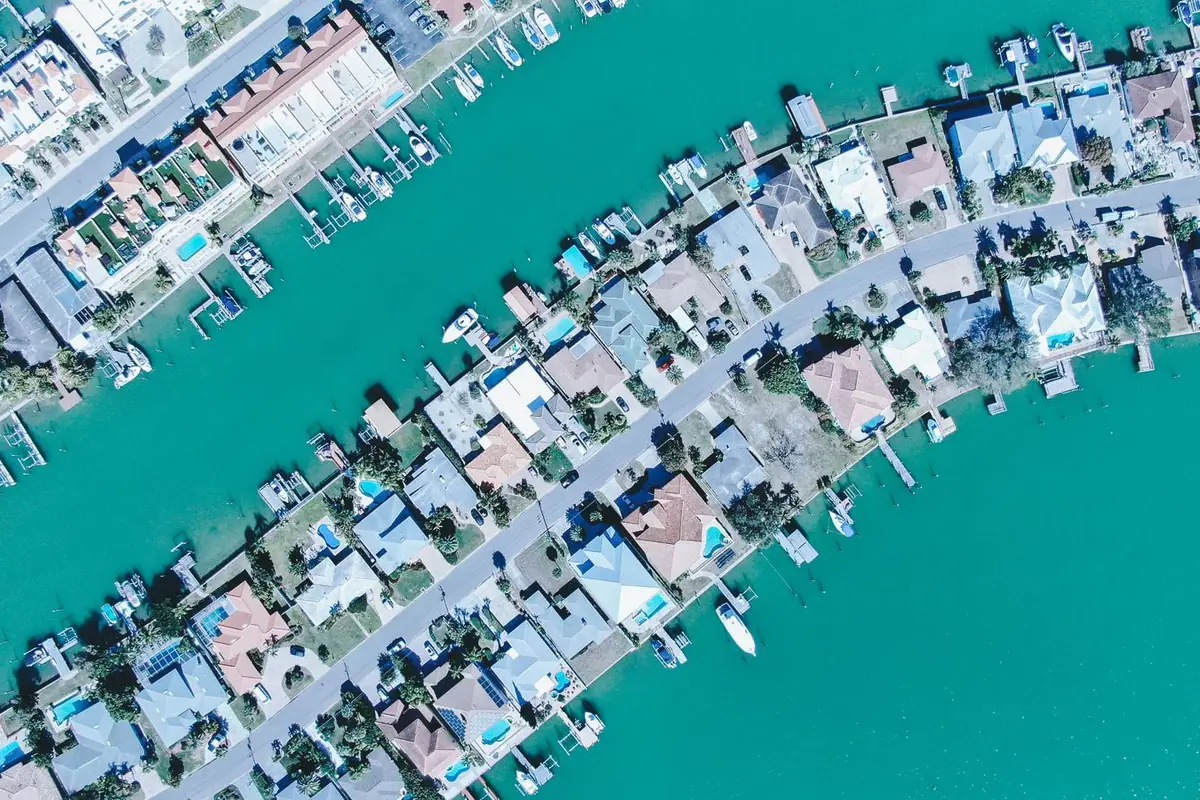 Aerial view of waterfront homes with docks and boats along both sides of a canal