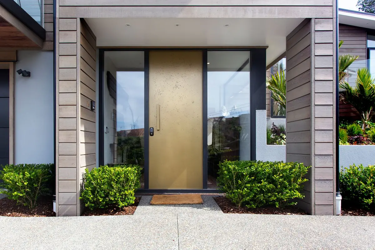 A tall bronze-finish front door with glass sidelights on both sides